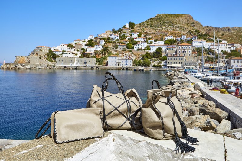 MyHydra Concept Store — leather bags on Hydra seafront rocks